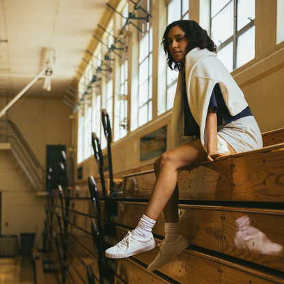 Person sitting on wooden bleachers in a gymnasium