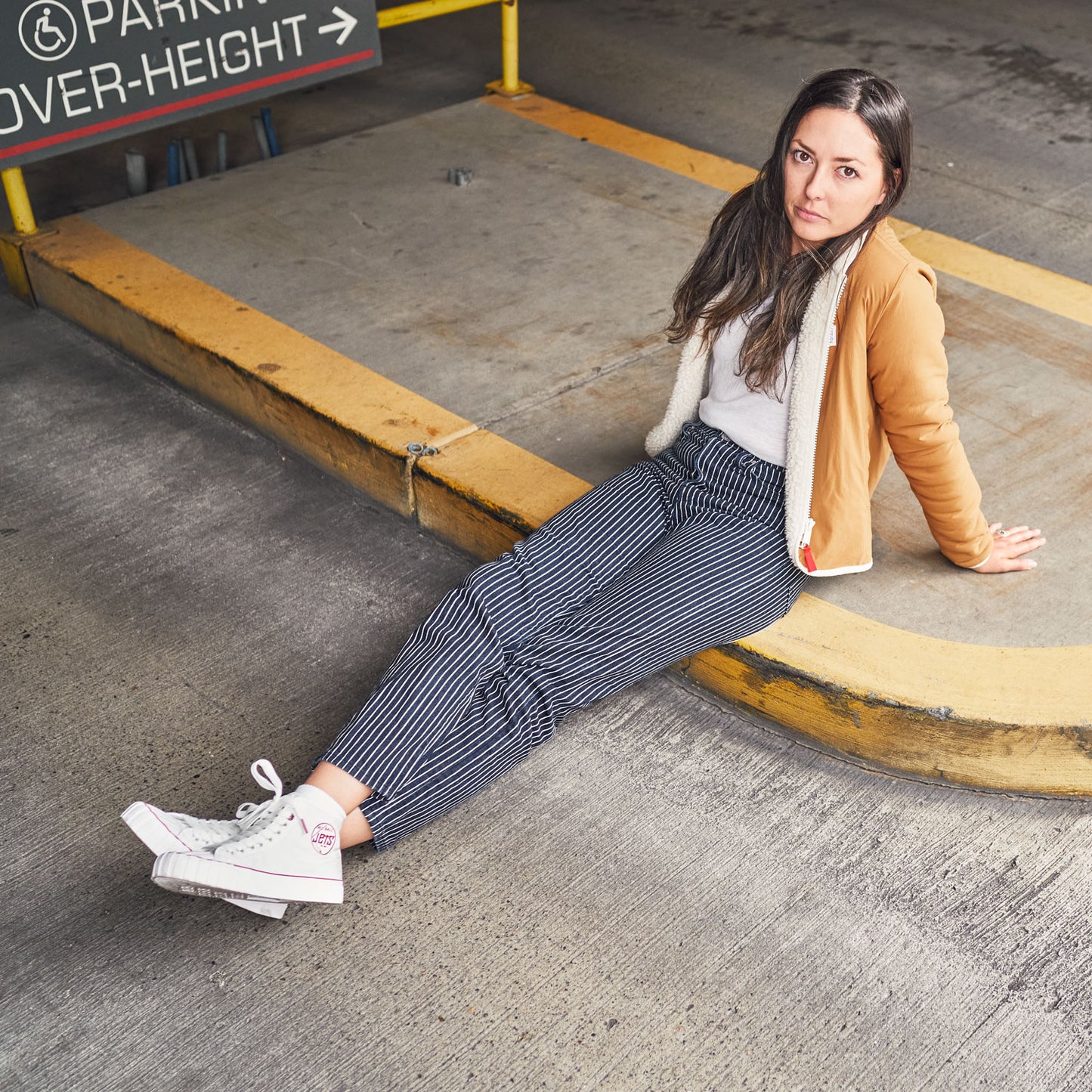 a person sitting on the ground wearing white 51 hi's