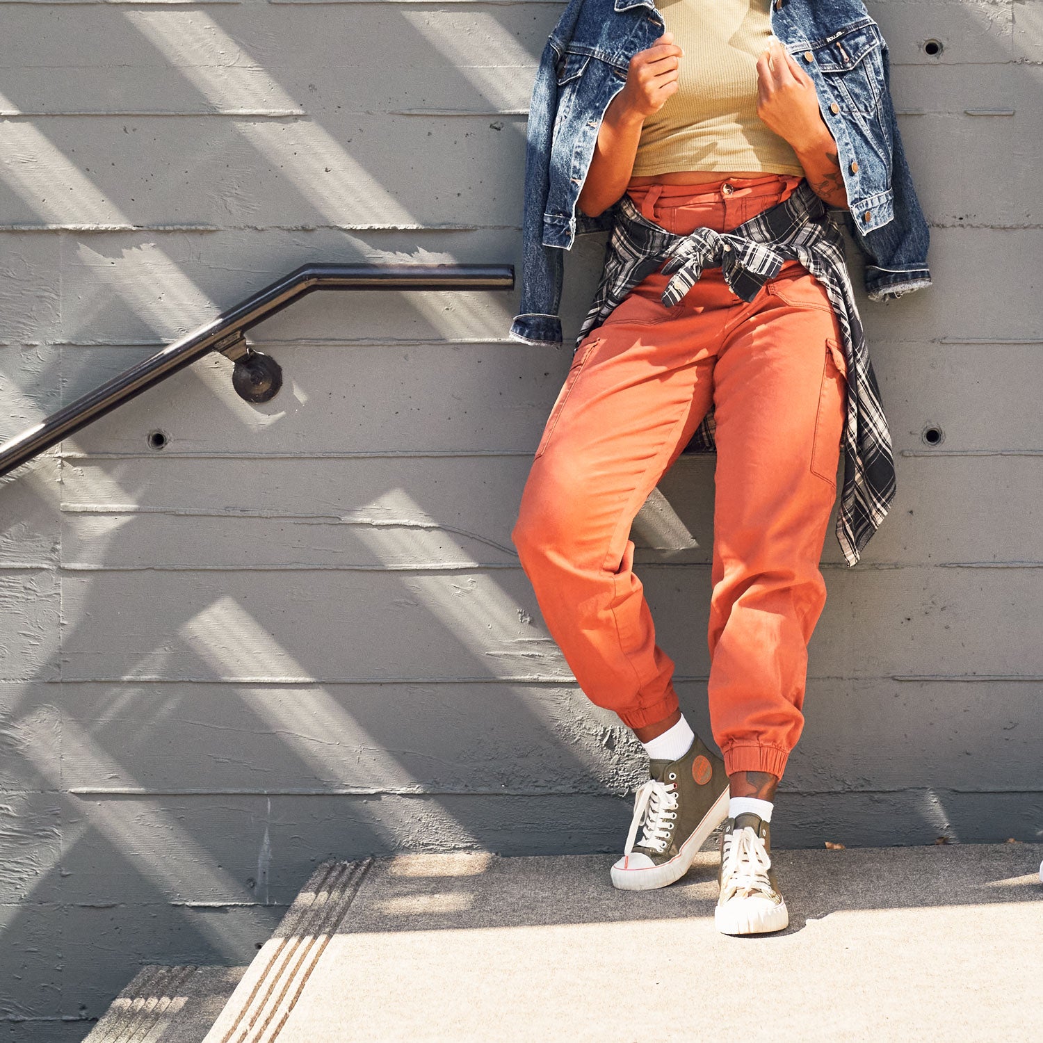 a person leaning against a wall wearing the olive 51 hi