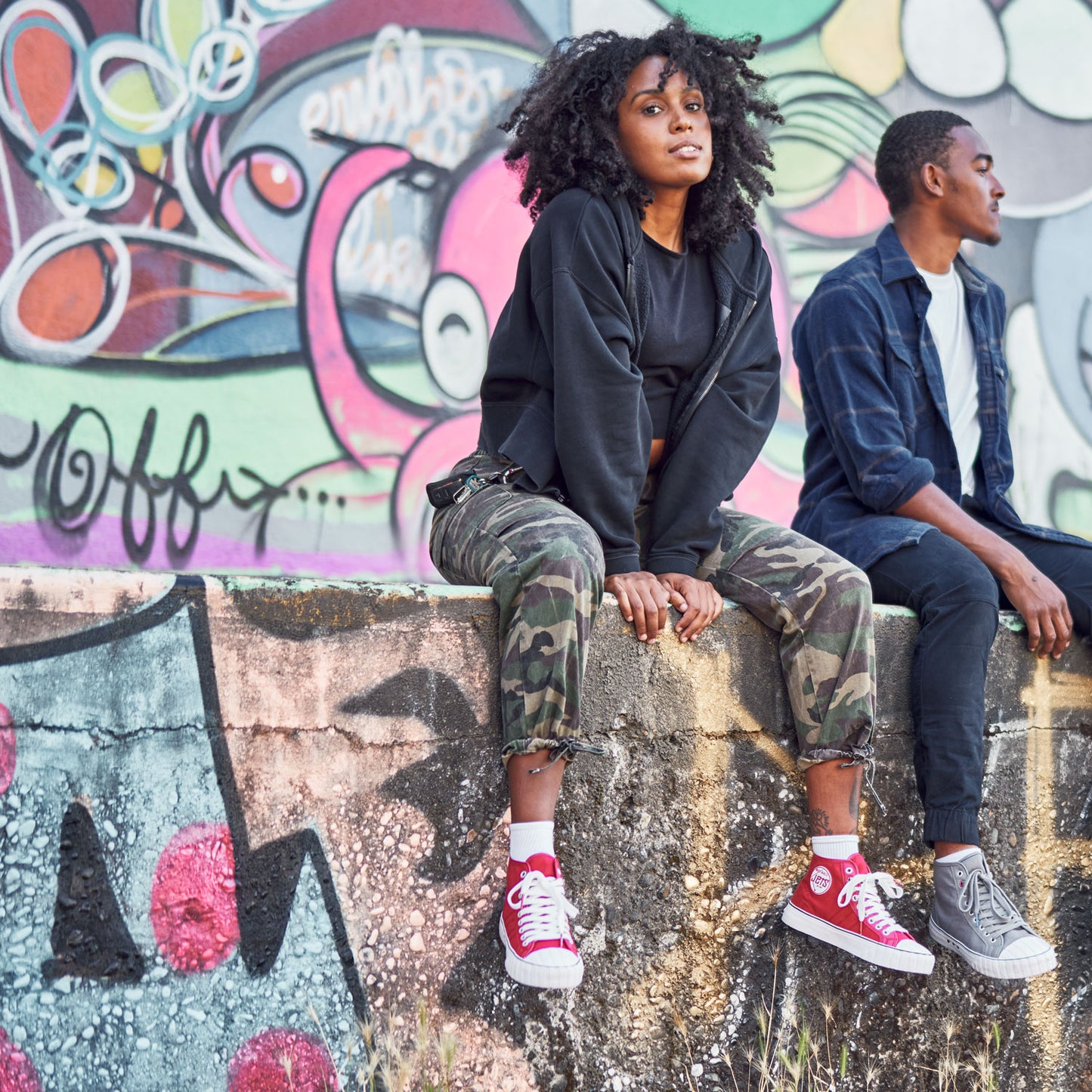 2 people sitting on a loading dock wearing red ball jets sneakers